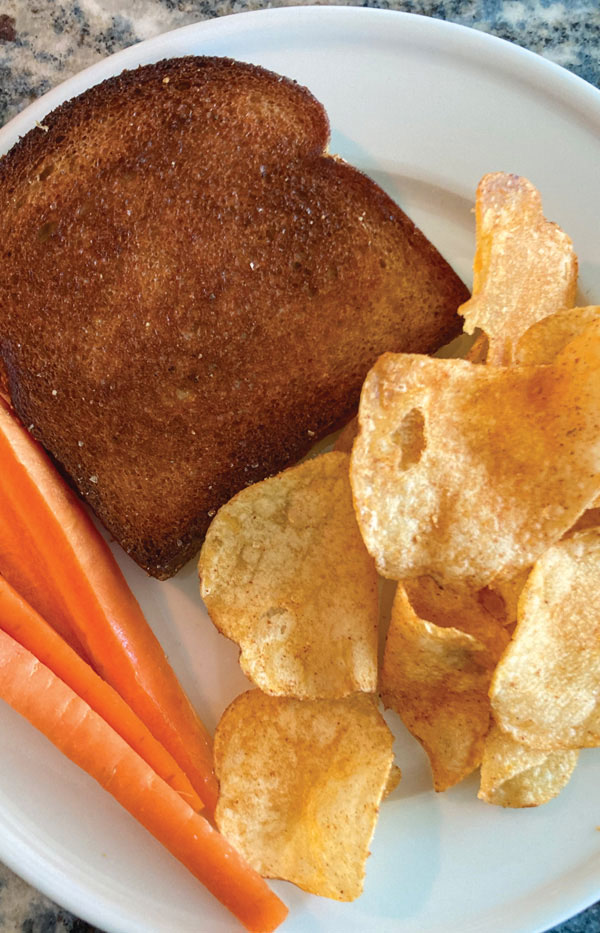 Grilled Cheese Sandwich shown on plate with BBQ chips and sliced carrots.