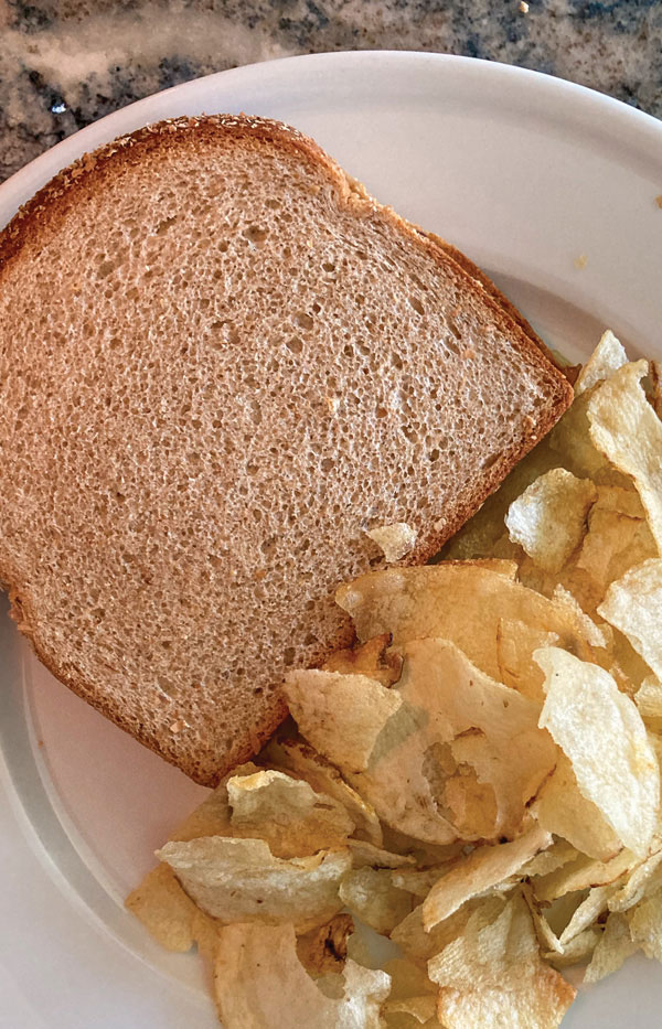 Peanut Butter & Jam Sandwich shown on a plate with potato chips.