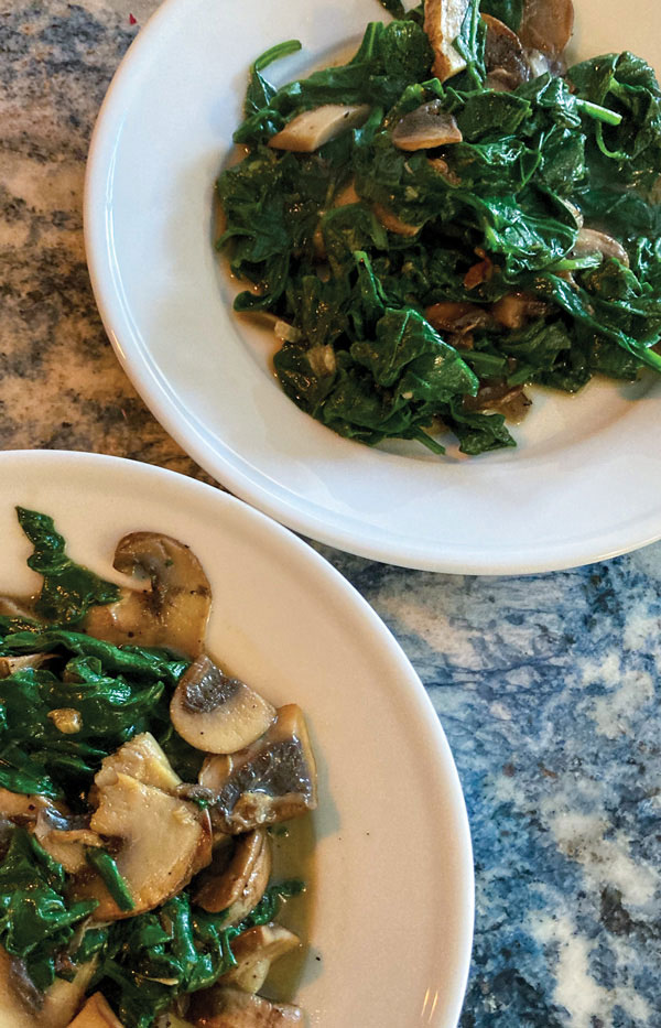 Sautéed Baby Spinach & Garlic shown on plates.